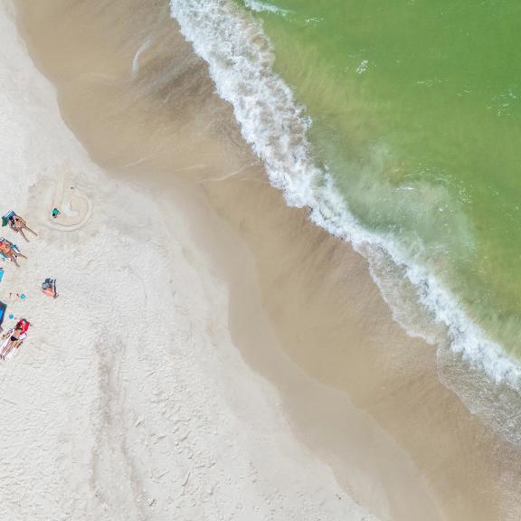 Aerial view of a family lounging on the beach in Orange Beach